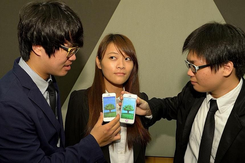 Republic Polytechnic’s winning team (from left) Libern Lin Yue Bin, Fang Ling Qing and Lester Yap Jian Le, all 20, displaying their winning app, Apple Tree, which aims to get people to spend more face time with each other. They won a $30,000 grant 