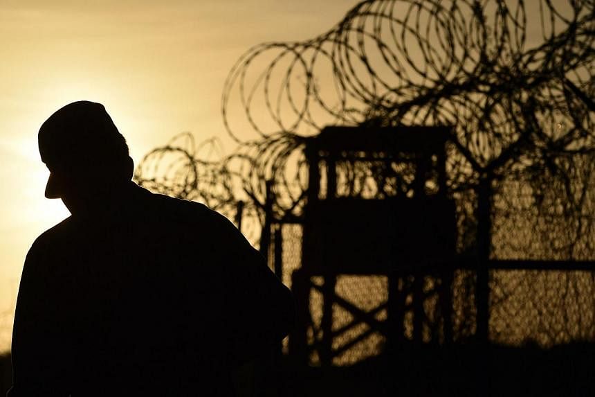 A US soldier walking next to the razor wire-topped fence at the abandoned "Camp X-Ray" detention facility at the US Naval Station in Guantanamo Bay, Cuba. -- PHOTO: AFP