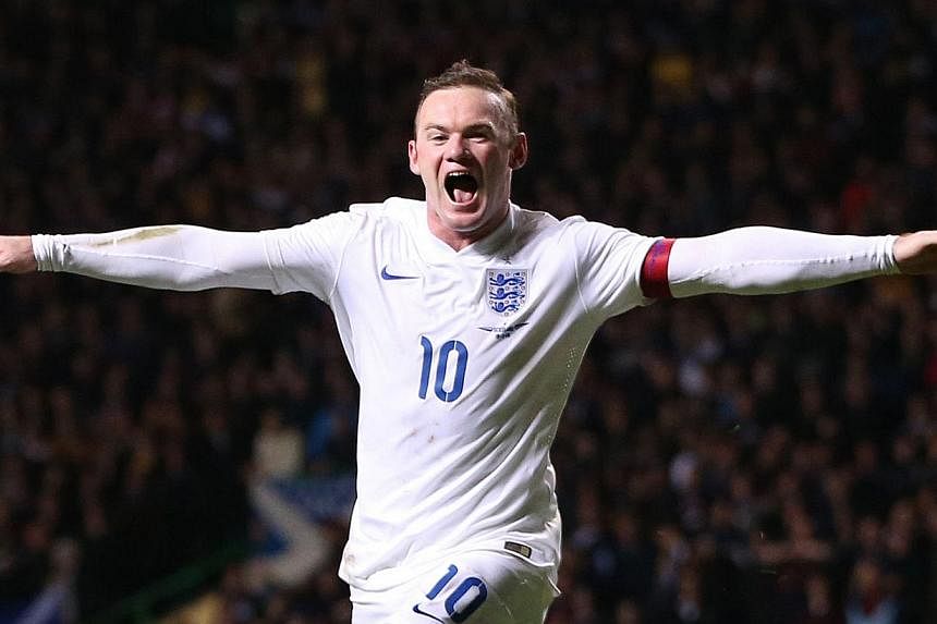 England's striker Wayne Rooney celebrates scoring their third goal during the international friendly football match between Scotland and England at Celtic Park in Glasgow, Scotland, on Nov 18, 2014. -- PHOTO: AFP