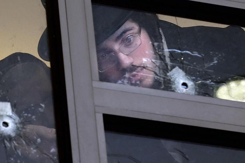 Ultra Orthodox Jews on Nov 19, 2014&nbsp;look at bullet holes in the main window of a synagogue in Jerusalem which was attacked the previous day by two Palestinians armed with a gun and meat cleavers, leaving five Israeli worhipers killed. -- PHOTO: 