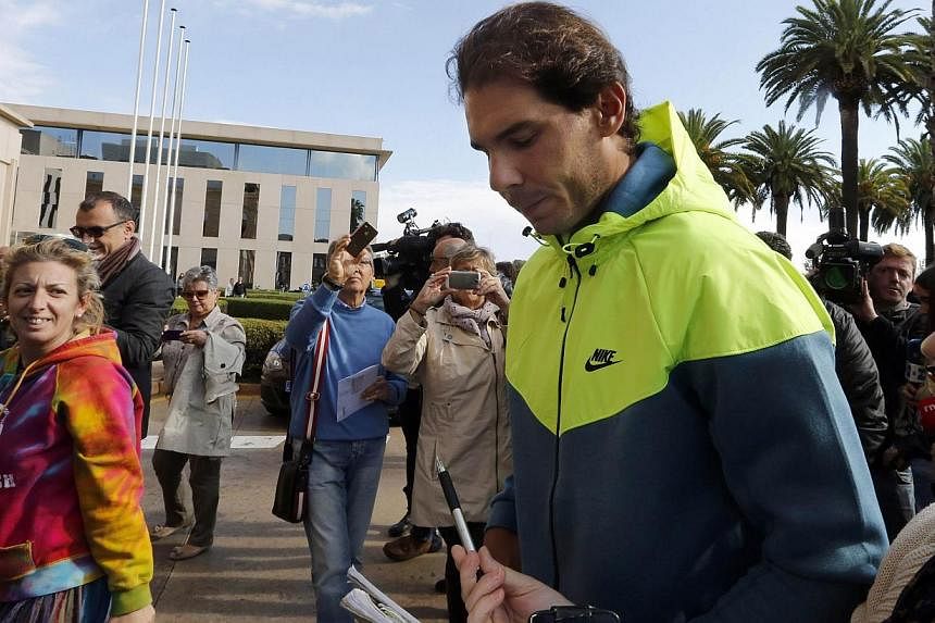 Spanish tennis player Rafael Nadal signs an autograph as he leaves the hospital after appendicitis surgery in Barcelona on Nov 5, 2014. Nadal is aiming to be fit for the Australian Open in January as he recovers from an appendicitis operation, the Sp