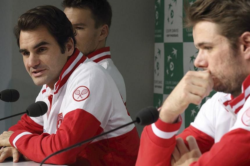 Switzerland's Davis Cup team player Roger Federer (left) and teammate Stanislas Wawrinka attend a news conference at the Pierre Mauroy stadium in Villeneuve d'Ascq, northern France, Nov 18, 2014.&nbsp;&nbsp;Federer said Tuesday he was "hopeful" he wo