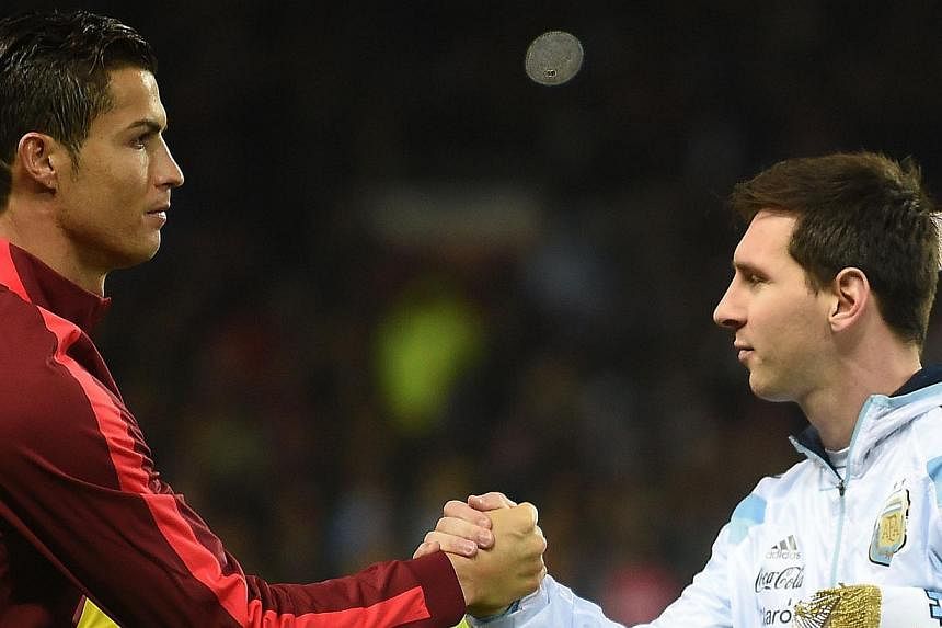 Argentina striker Lionel Messi (right) shakes hands with Portugal's striker Cristiano Ronaldo (left) ahead of kick off of the international friendly football match between the Argentina and Portugal at Old Trafford in Manchester on Nov 18, 2014. -- P
