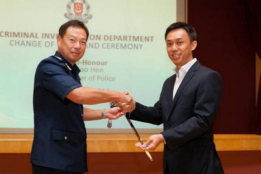 Senior Assistant Commissioner of Police Tan Chye Hee (right) receiving the Command Sword from Commissioner of Police Ng Joo Hee. -- PHOTO: SINGAPORE POLICE FORCE