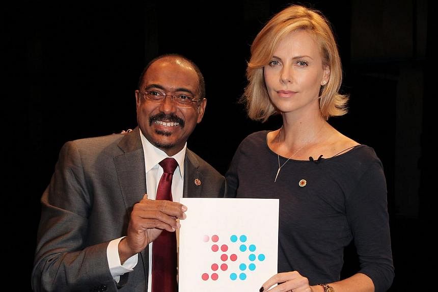Executive Director of UNAIDS Michel Sidibe (left) and actress Charlize Theron attend the launch of UNAIDS New Fast Track Report ahead of World AIDS Day 2014 at UCLA on Nov 18, 2014. -- PHOTO: AFP