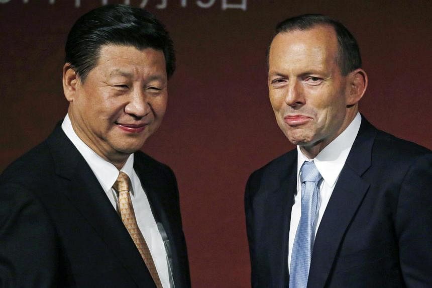 China's President Xi Jinping (left) and Australia's Prime Minister Tony Abbott are pictured on stage after addressing the Australia-China state and provincial leaders forum in Sydney, Australia on Nov 19, 2014. -- PHOTO: REUTERS