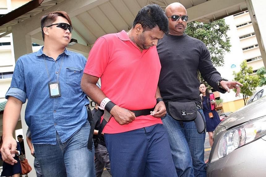 Annadurai Raman (in red), who was charged in connection with robbing money changer Ali Yousouf Saiboo of $600,000, took police to Block 125, Geylang East Avenue 1, to give a recount of the alleged incident on Nov 18, 2014.&nbsp;Two of the men alleged