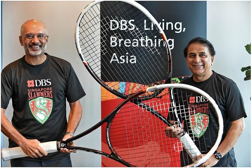 Chairman of Singapore Slammers and internationally acclaimed cricketer Sunil Gavaskar (right) and Piyush Gupta (left), CEO of DBS group, pose with very large tennis rackets after a press conference in Singapore on Nov 20, 2014.&nbsp;Local bank DBS an