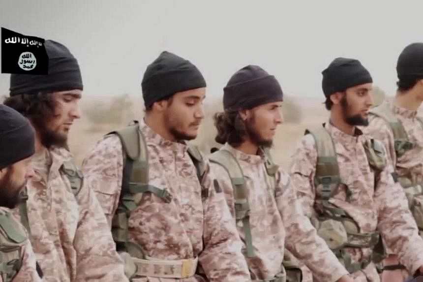 An image grab taken from a propaganda video released on Nov 16, 2014, by al-Furqan Media allegedly shows members of the Islamic State jihadist group preparing the simultaneous beheadings of at least 15 men described as Syrian military personnel. -- P