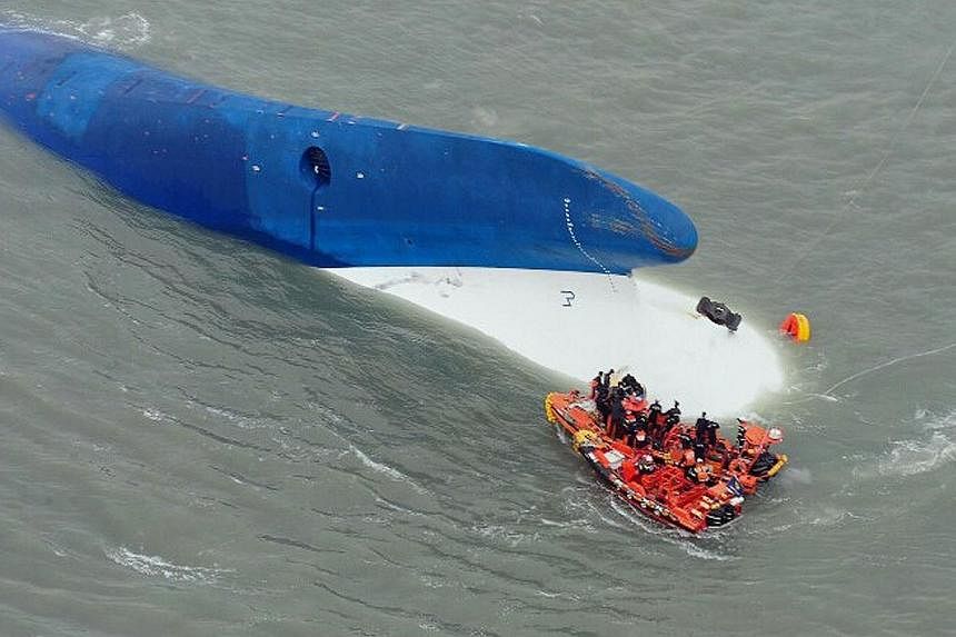 This aerial handout file photo by the South Korea Coast Guard taken at sea some 20 kilometres off the island of Byungpoong in Jindo on April 16, 2014 shows coast guard members searching for passengers near a South Korean ferry (centre) that capsized 