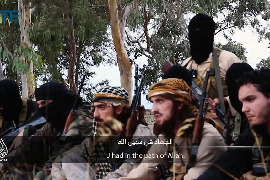 This still from video provided by private terrorism monitor SITE Intelligence Group on November 19, 2014 shows Abu Maryam(centre), Abu Osama(second right) and Abu Salman(right), French fighters sitting with other fighters in the Isalmic State group.&