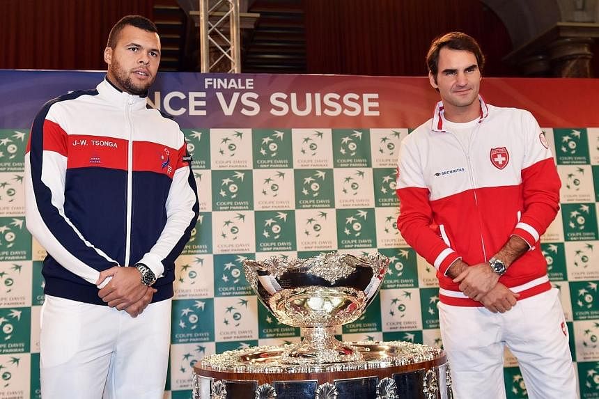 Swiss Davis Cup team player Roger Federer (right) poses with French Davis Cup team player Jo-Wilfried Tsonga next to the Davis Cup trophy after the draw of the Davis Cup final France vs Switzerland on Nov 20, 2014, in Lille.&nbsp;Switzerland's tennis