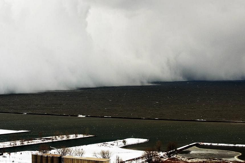 A Lake Effect snow storm with freezing temperatures produces a wall of snow travelling over Lake Erie into Buffalo, New York on Nov 18, 2014. -- PHOTO: REUTERS