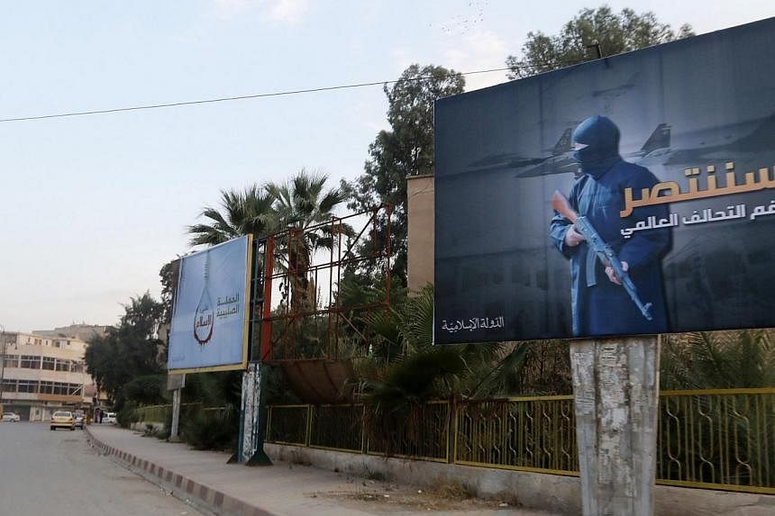 Islamic State in Iraq and Syria billboards are seen along a street in Raqqa, eastern Syria, which is controlled by the group, on October 29, 2014. The billboard on the right reads: "We will win despite the global coalition". -- PHOTO: REUTERS