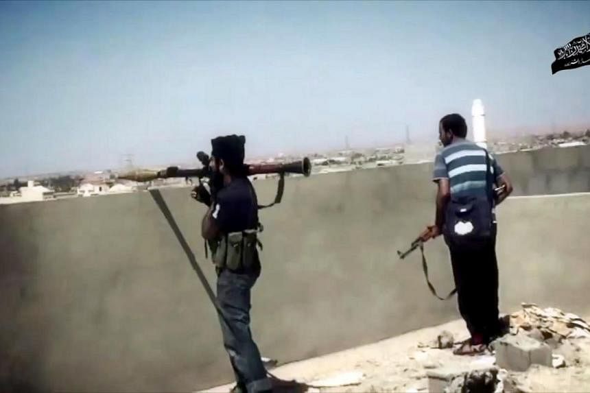 An image taken from a video made available on Oct 9, 2014, allegedly shows Ansar al-Sharia militants during a battle in the Libyan city of Benghazi, the country's second biggest city. -- PHOTO: AFP
