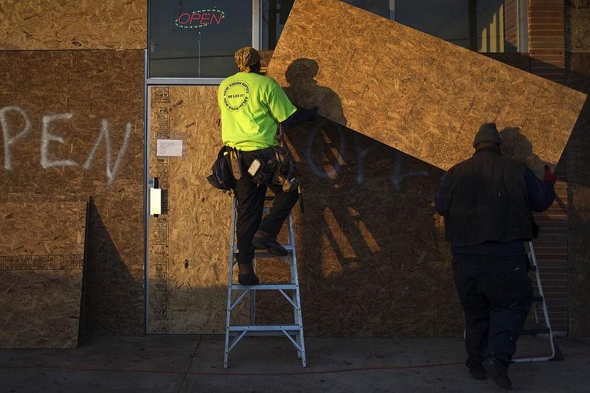 Workers board up businesses in preparation for the grand jury verdict in the shooting death of Michael Brown in Ferguson, Missouri on Nov 19, 2014. -- PHOTO: REUTERS