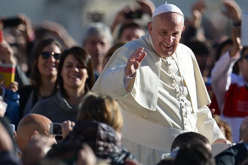 Pope Francis greets the crowd as he arrives for his general audience at St Peter's square on November 19, 2014 at the Vatican. Pope Francis is raffling off unwanted gifts including a Fiat Panda, tandem bike and coffee machine to raise money for the h