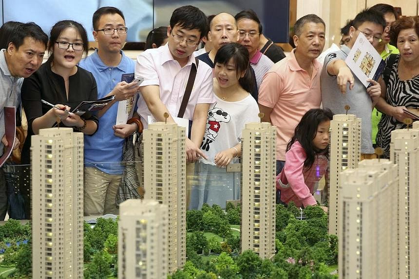Customers look at a model of a new residential compound at a showroom of Longfor Properties, in Hangzhou, Zhejiang province, in this Aug 17, 2014 file picture.&nbsp;Credit rating agency Standard and Poor's said on Wednesday that China's over-priced a