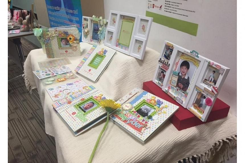 Two of eight items of the SG50Baby Jubilee Gift were unveiled on Thursday. They include a white photo frame and a scrapbook set. -- ST PHOTO: AUDREY TAN