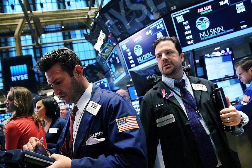 Traders work on the floor of the New York Stock Exchange (NYSE) in New York City on Nov 18, 2014. -- PHOTO: AFP