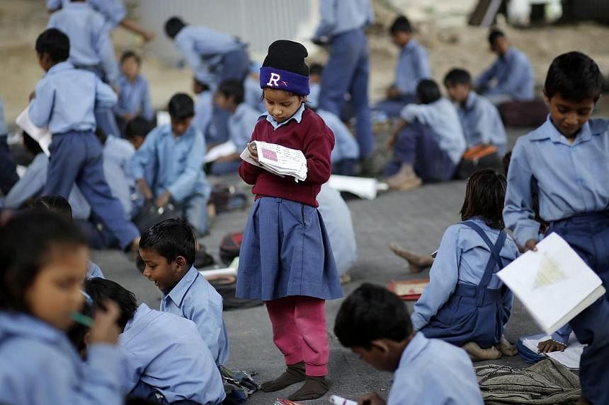 A schoolgirl reads from a textbook at an open-air school in New Delhi on Nov 20, 2014.&nbsp;Indians were flying aeroplanes, carrying out stem cell research and may even have been using cosmic weapons 5,000 years ago, according to the chairman of Indi