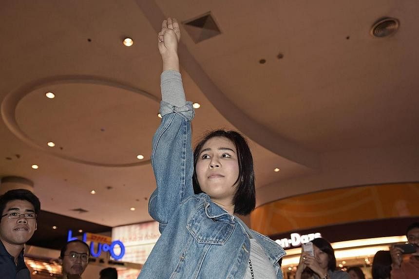 &nbsp;A Thai student flashes a three-finger salute, an unofficial symbol of resistance against the army's May coup, at a cinema hall in Bangkok on Nov 20, 2014. -- PHOTO: AFP