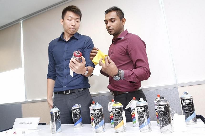 Investigators from Tanglin Police Division with seized items from the vandals at a police conference at Cantonment Complex on Nov 21, 2014. -- ST PHOTO: KEVIN LIM