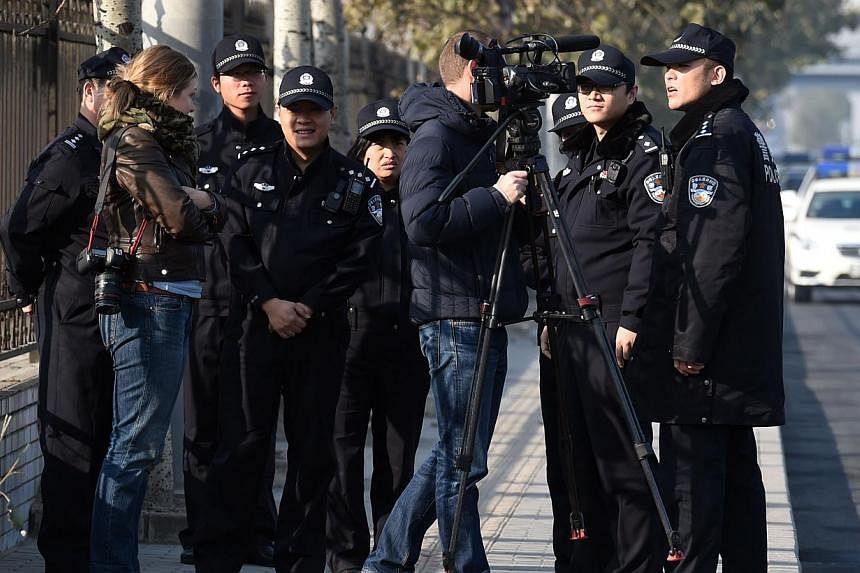 Police order foreign journalists to leave the street opposite the Beijing No. 3 Intermediate People's Court where the trial of veteran former journalist Gao Yu on charges of leaking state secrets takes place in Beijing on Nov 21, 2014.&nbsp;An outspo