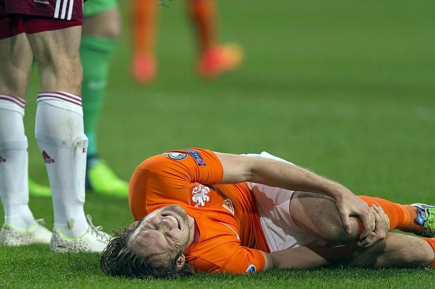 Daley Blind of the Netherlands lies injured after a challenge with Latvia's Eduards Viskanovs during their Euro 2016 Group A qualifying soccer match in Amsterdam Nov 16, 2014. The&nbsp;Manchester United midfielder's knee ligament injury is not as bad