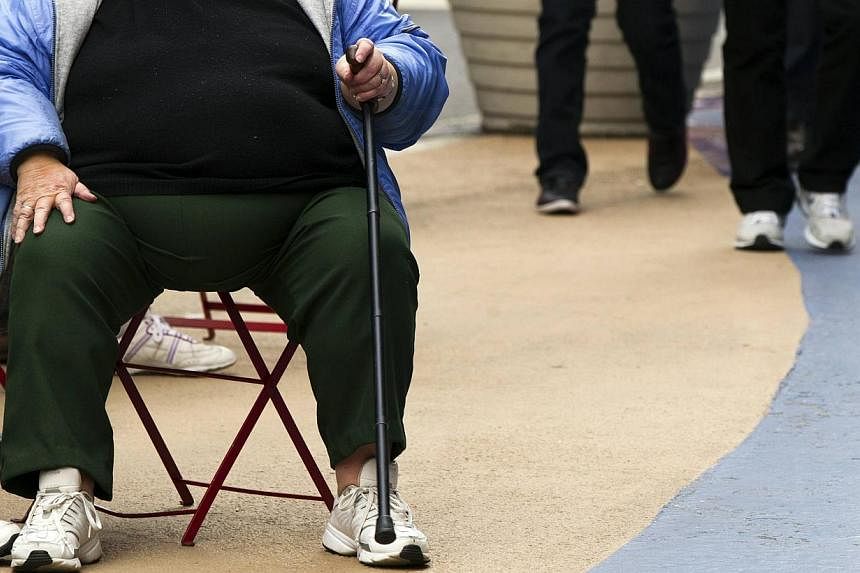 An overweight woman sits on a chair in Times Square in New York, in this May 8, 2012 file photo.&nbsp;&nbsp;More than 2.1 billion people globally, or nearly 30 per cent of the world's population, are now overweight or obese, with the figure set to ri