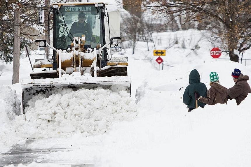 Heavy machinery clears snow from a street following an autumn storm in Buffalo, New York, Nov 20, 2014. Fresh snowstorms struck the northeastern US on Thursday, paralysing communities in a rare mid-autumn blizzard that killed eight people and dumped 