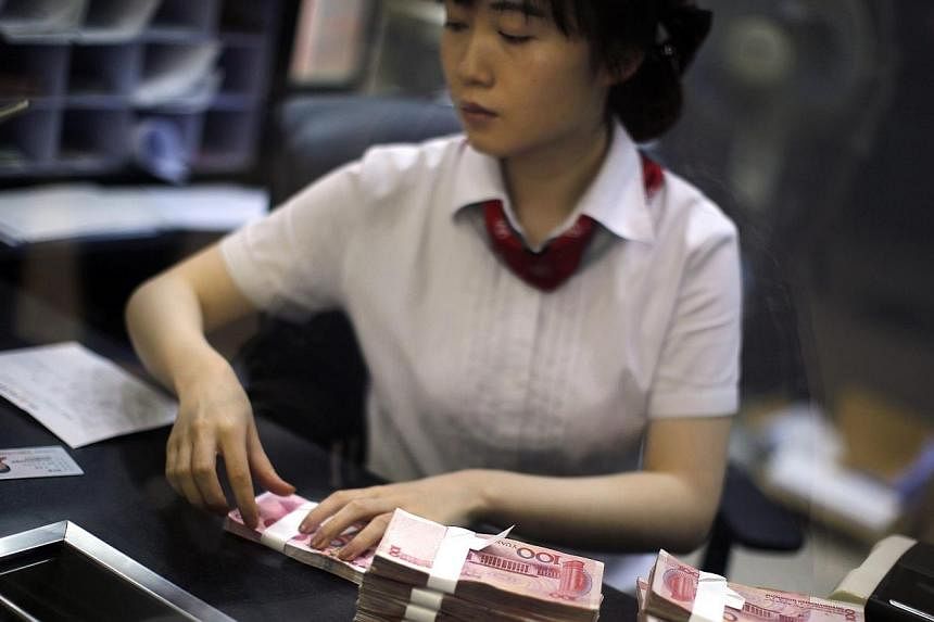An employee of the Industrial and Commercial Bank of China Ltd (ICBC) counts money at one of the bank's branches at the Shanghai Free Trade Zone in Pudong district, in Shanghai on Sept 24, 2014.&nbsp;China's Industrial and Commercial Bank (ICBC) sign
