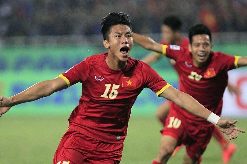 Vietnam's Que Ngoc Hai (front) celebrates with teammate Nguyen Van Quyet after scoring a goal during their Suzuki Cup match against Indonesia at My Dinh stadium in Hanoi on Nov 22, 2014. -- PHOTO: REUTERS&nbsp;