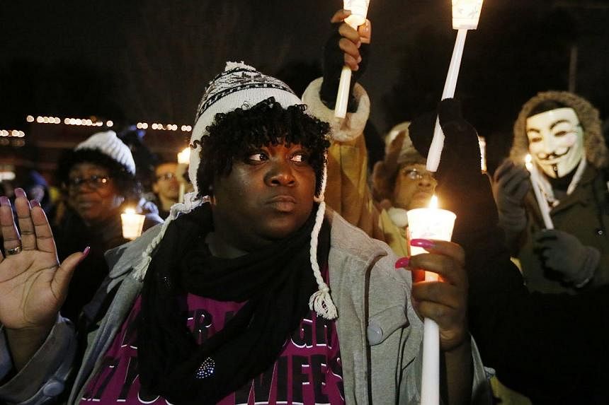 Protesters gather for a candlelight vigil over the Aug 9 police shooting of Michael Brown, outside the Ferguson Police Department in Ferguson, Missouri on Nov 21, 2014. -- PHOTO: REUTERS
