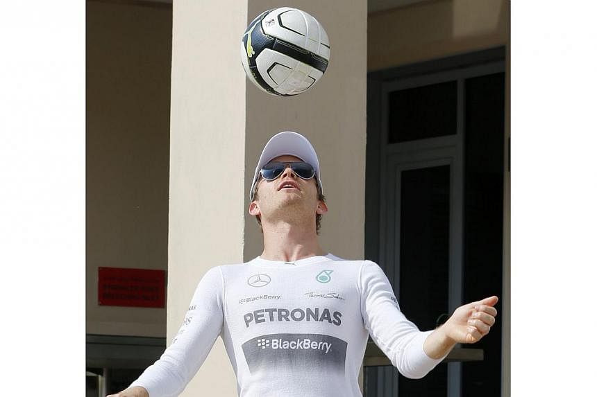 Mercedes Formula One driver Nico Rosberg of Germany playing soccer before the start of the first practice session of the Abu Dhabi Grand Prix at the Yas Marina circuit Nov 21, 2014. -- PHOTO: REUTERS