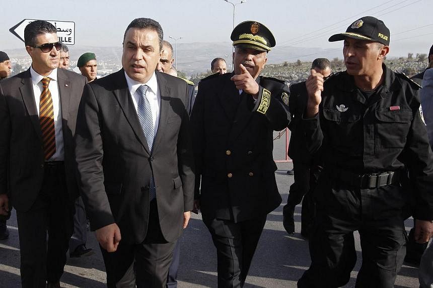 Tunisia's Prime Minister Mehdi Jomaa (front, in blue tie) inspects Tunisian police standing guard on the eve of presidential elections, in Beja on Nov 22, 2014. -- PHOTO: REUTERS