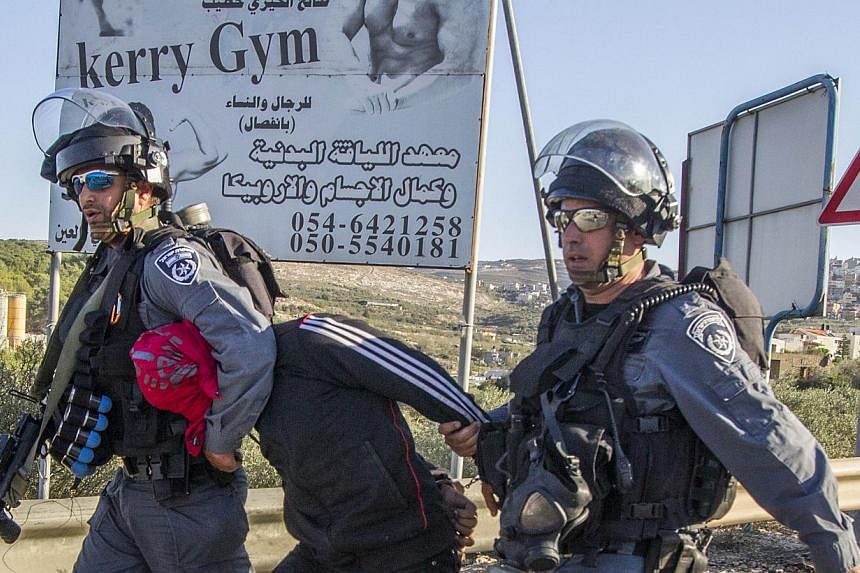 Israeli security forces detain an Arab-Israeli youth during clashes in the town of Kfar Kana, in northern Israel on November 9, 2014, a day after security forces shot dead a 22-year-old Arab-Israeli man. -- PHOTO: AFP