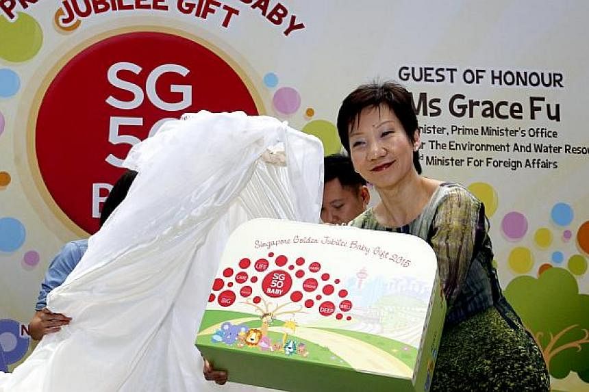 Minister in the Prime Minister's Office Grace Fu unveiled the SG50 Baby Jubilee Gift, a specially-designed suitcase containing eight items such as a medallion, a set of baby clothes and a shawl, on Sunday. -- PHOTO: CHEW SENG KIM
