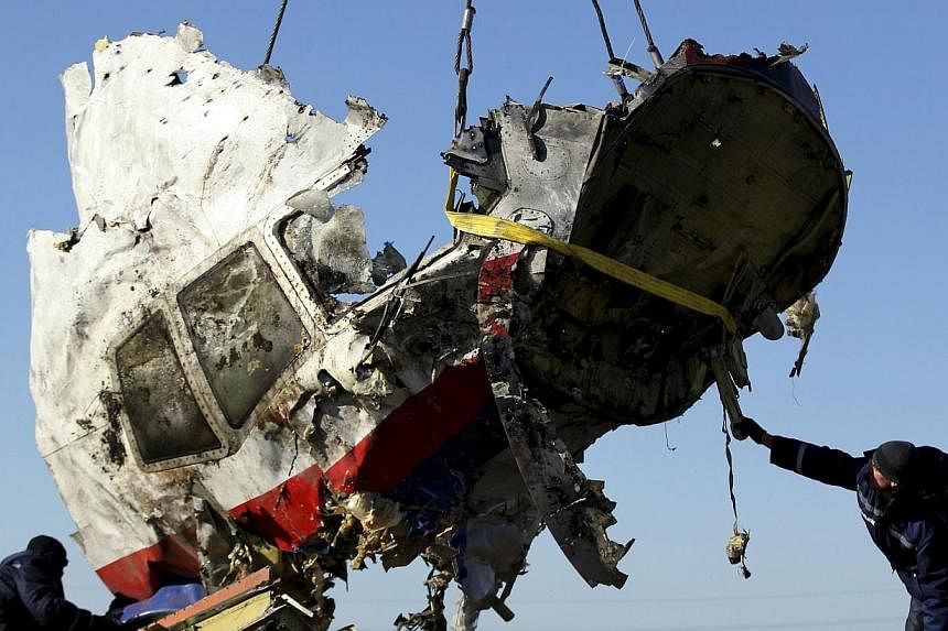 Local workers transport a piece of the Malaysia Airlines flight MH17 wreckage at the site of the plane crash near the village of Hrabove (Grabovo) in Donetsk region, eastern Ukraine on November 20, 2014. -- PHOTO: REUTERS