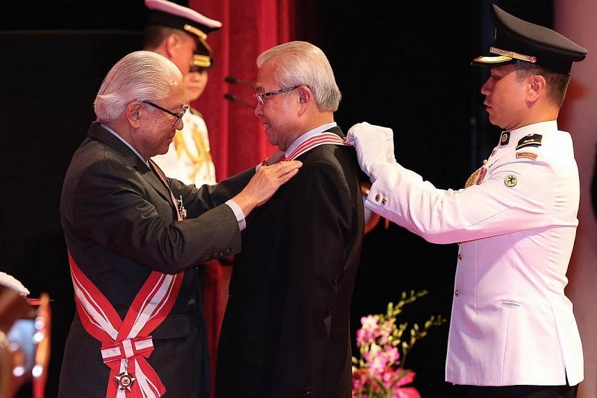 Mr Chua Thian Poh (centre) receives the Distinguished Service Order from President Tony Tan Keng Yam (extreme left) at the Investiture of the 2014 National Day Awards held at the NUS University Cultural Centre on Nov 23, 2014. -- ST PHOTO: NEO XIAOBI