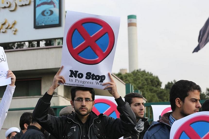 Iranian students hold placards during a demonstration outside the Teheran Research Reactor in the capital city on Nov 23, 2014, to show their support to Iran's nuclear programme. Iran and six world powers are holding talks in Vienna to reach a lastin