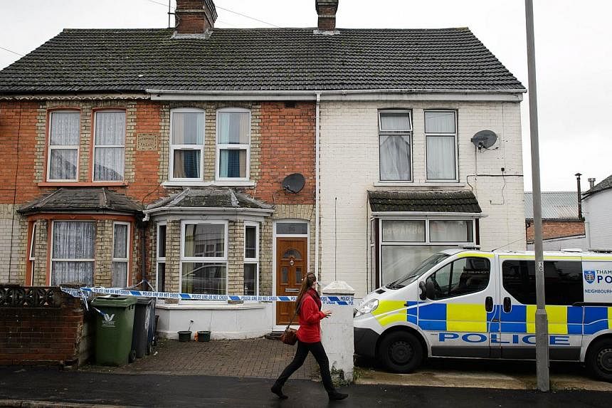 A pedestrian walks past a residential address marked off by police tape in High Wycombe, Buckinghamshire, north west of London, on November 8, 2014, in connection with the arrest of four anti-terror suspects. -- PHOTO: AFP