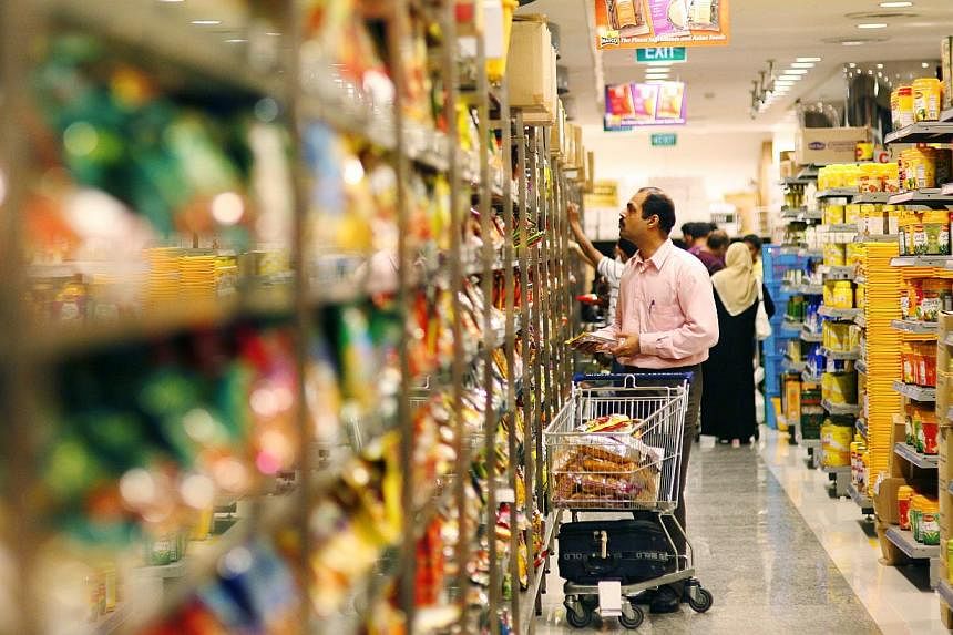 Shoppers perusing products on the shelves of Mustafa Centre's supermarket. The Singapore Consumer Price Index for October will be released on Nov 24, 2014, at 1pm. -- PHOTO: ST FILE