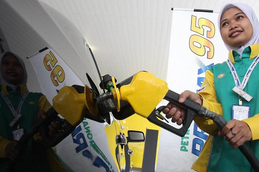 A pump attendant filling up a car with RON 95 at a Petronas station in Malaysia. -- PHOTO: THE STAR&nbsp;