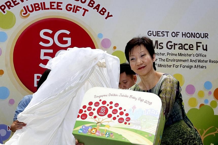 Minister in the Prime Ministers Office, Grace Fu unveiling the contents of the SG50Baby Jubilee Gift at a year-end gathering of about 200 Singaporean family partners. -- ST PHOTO: CHEW SENG KIM&nbsp;