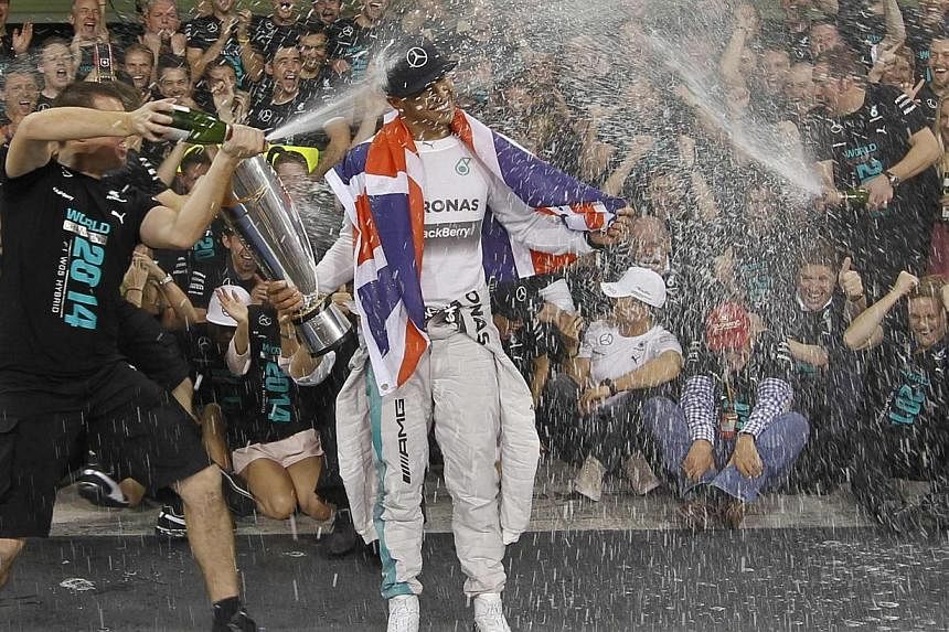 Mercedes Formula One driver Lewis Hamilton of Britain celebrates with his team after winning the Abu Dhabi F1 Grand Prix at the Yas Marina circuit in Abu Dhabi on Nov 23, 2014. -- PHOTO: REUTERS