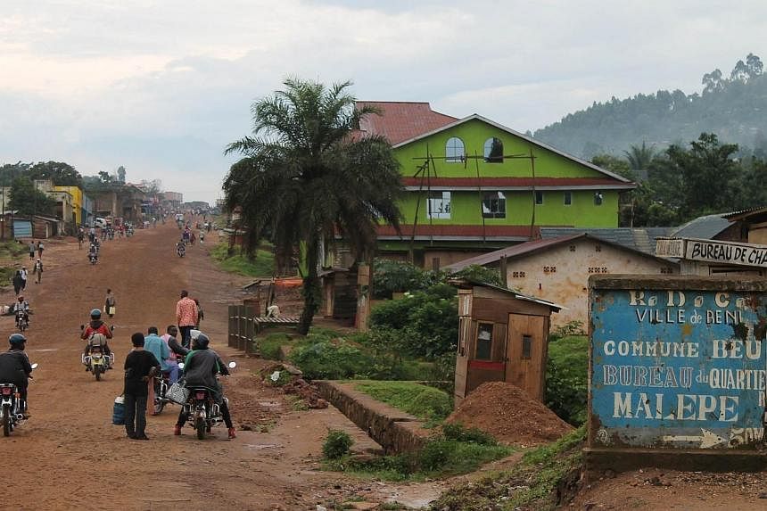 People walking and riding motorcycles in a street of the town of Beni, in the north east of the Democratic Republic of Congo, on Oct 20, 2014.&nbsp;About 100 people were slaughtered last week in the east of the Democratic Republic of Congo near Beni 