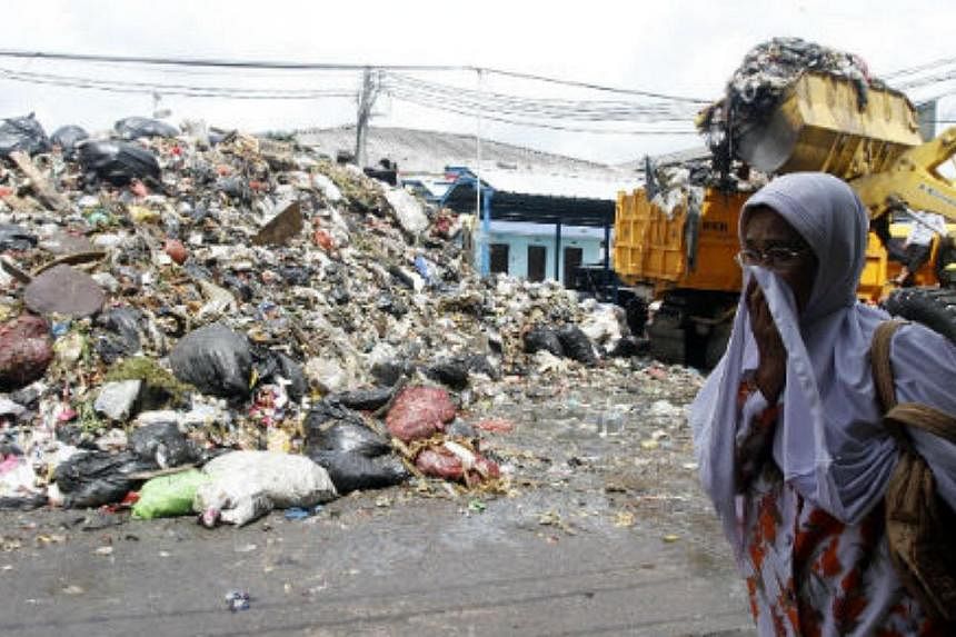 A woman walks past a pile of garbage in Bandung, West Java. -- PHOTO: THE JAKARTA POST/ASIA NEWS NETWORK