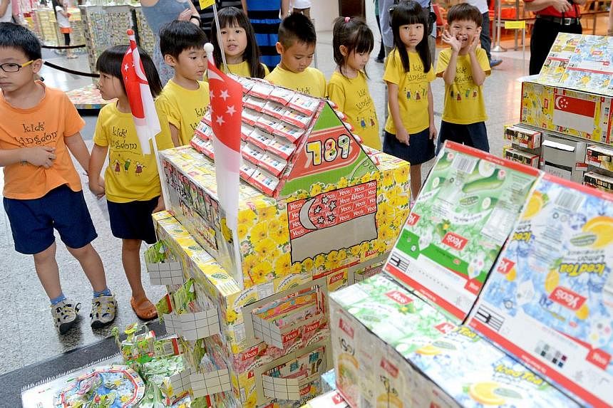 Kindergarten children looking at housing structures made of recycled material. A scheme has been launched to encourage pre-schoolers to help protect the environment.-- PHOTO: ST FILE