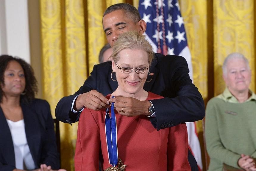US President Barack Obama presenting the Medal of Freedom to actress Meryl Streep during a ceremony in the East Room of the White House on Nov 24, 2014. -- PHOTO: AFP &nbsp;